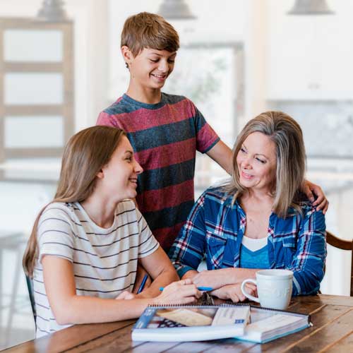 Mom and kids going over course work at a table